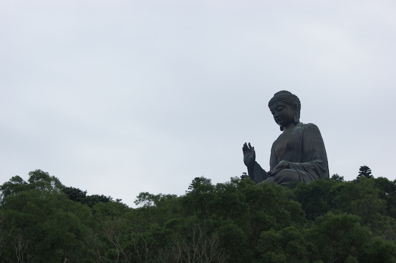 The Tian Tan Buddha floats on the trees